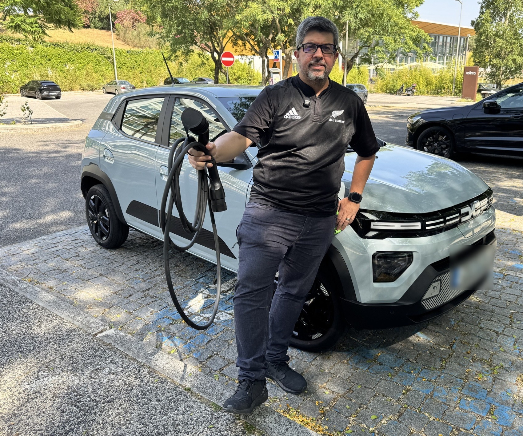 Freire Neto com o Dacia Spring Extreme e o cabo de carregamento