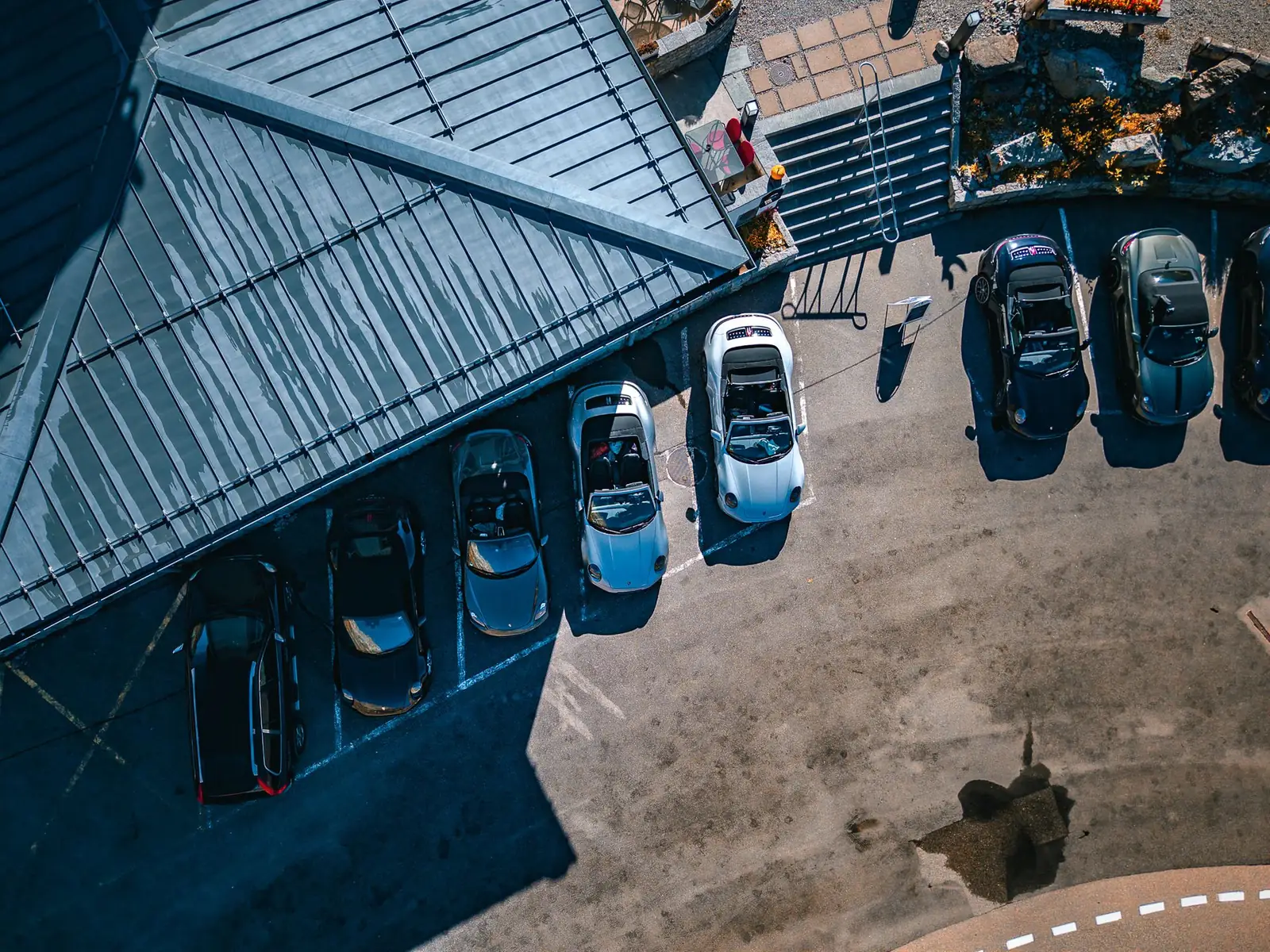 Vista de drone dos Porsche 911 Cabriolet do comboio da ROXMOTORS estacionados durante parada nos Alpes suíços