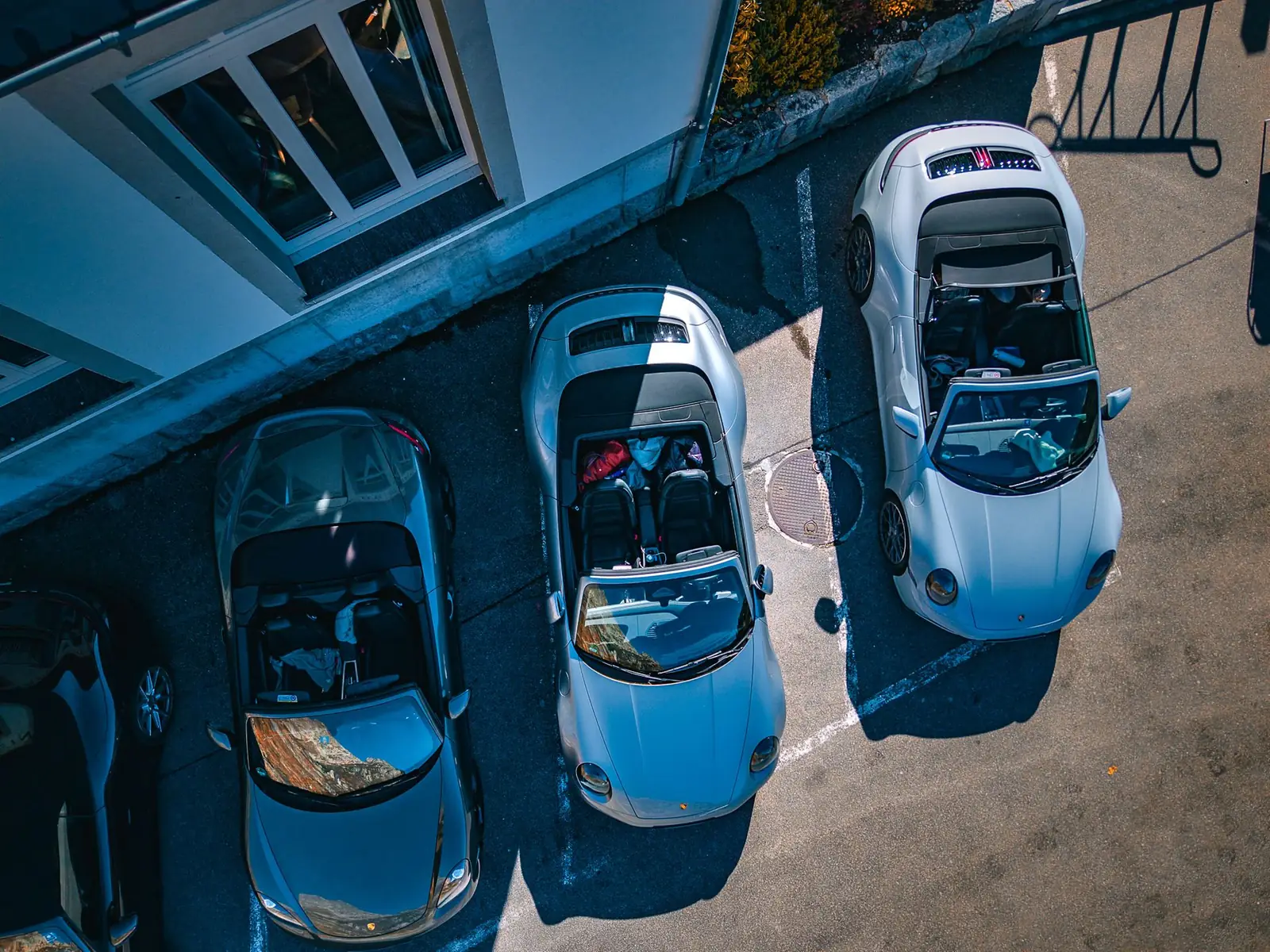 Três Porsche 911 Cabriolet de capota aberta vistos de cima durante o Legends of the Alps da ROXMOTORS